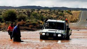 car stuck in floods that are blocking the road