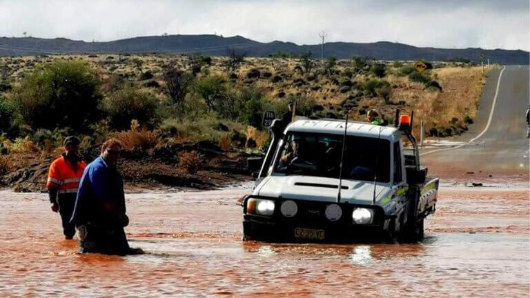 car stuck in floods that are blocking the road