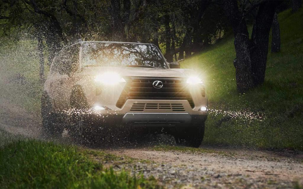 lexus gx driving through water in a forest