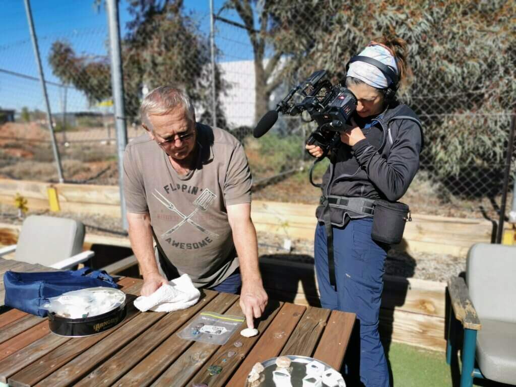 Peter shows us examples of some of the opals he has found over the years, Gelareh filming