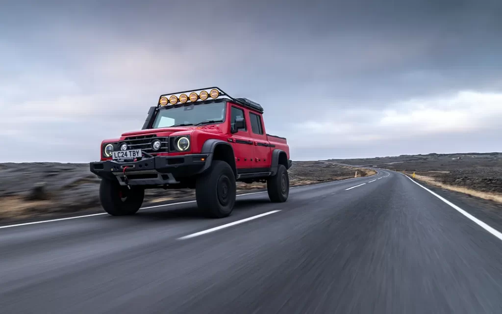 red ineos grenadier with portal axles driving on-road