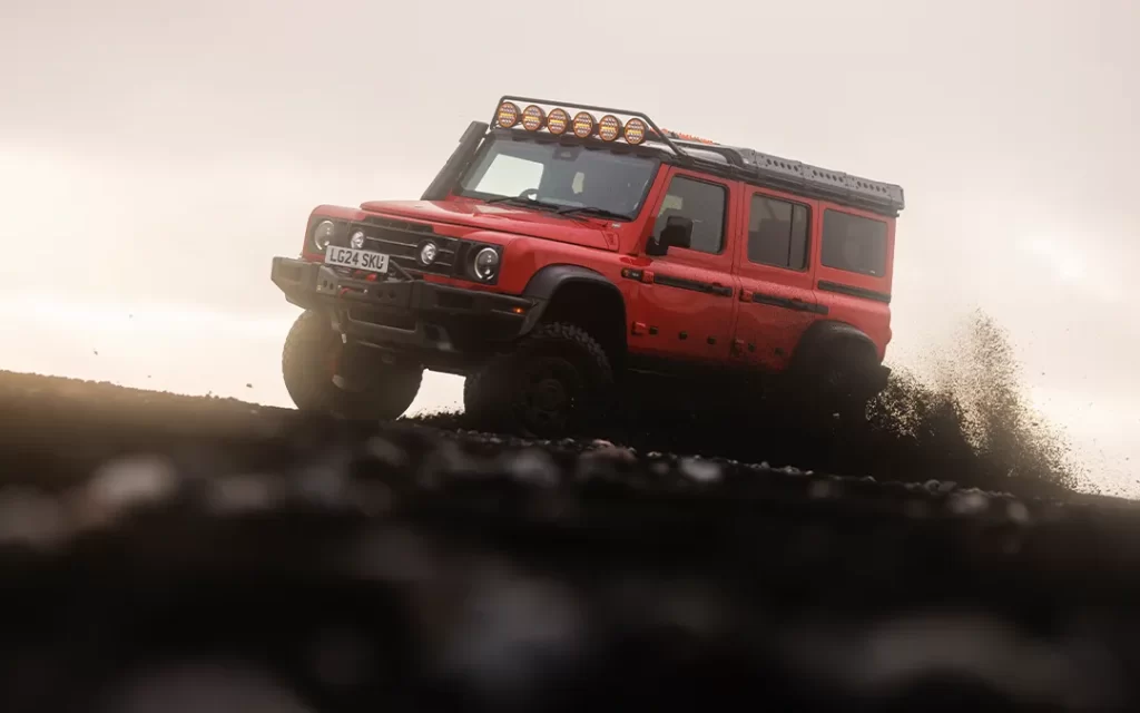 red ineos grenadier kicking up volcanic dust on iceland