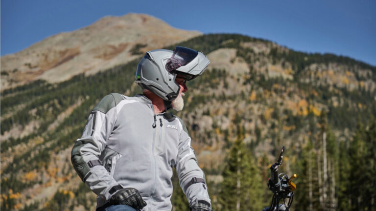 Motorcyclist sitting on his bike looking back at a mountain